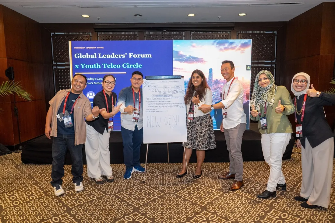 Participants posing with a New Gen flipchart after the forum